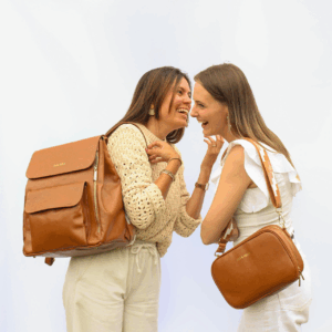 Frau trägt die Emi City Clutch in Cognac Leder elegant auf der schulter